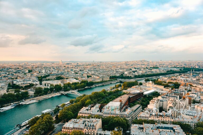 A stunning aerial view of Paris, showcasing the Seine River and iconic landmarks during sunset.